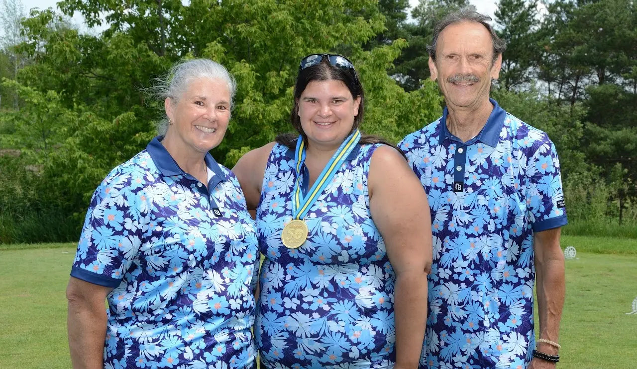 Three golfers wearing coordinating blue floral Shop Out of Bounds polos with a tournament medal