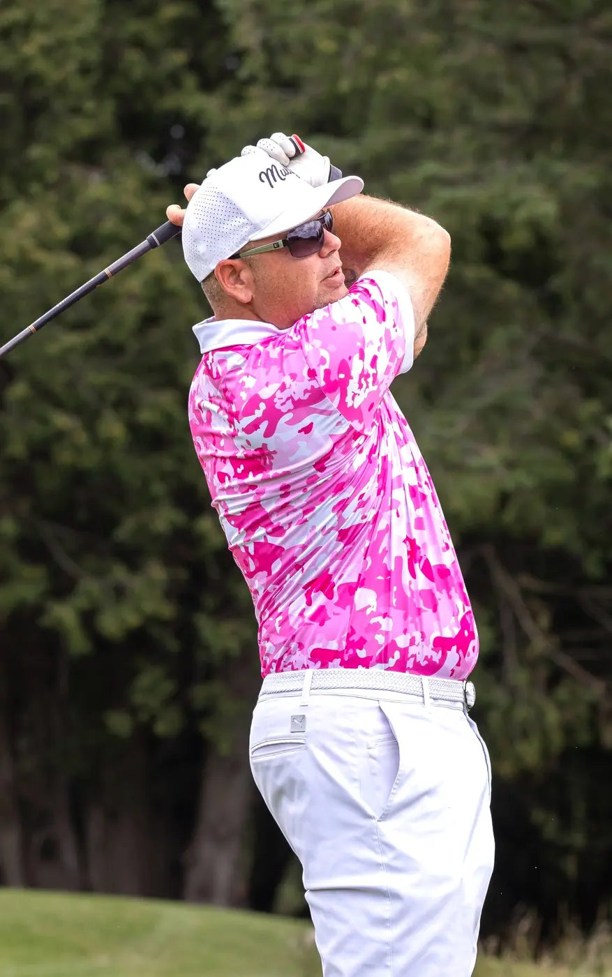 Golfer completing a swing in a bright pink Shop Out of Bounds polo