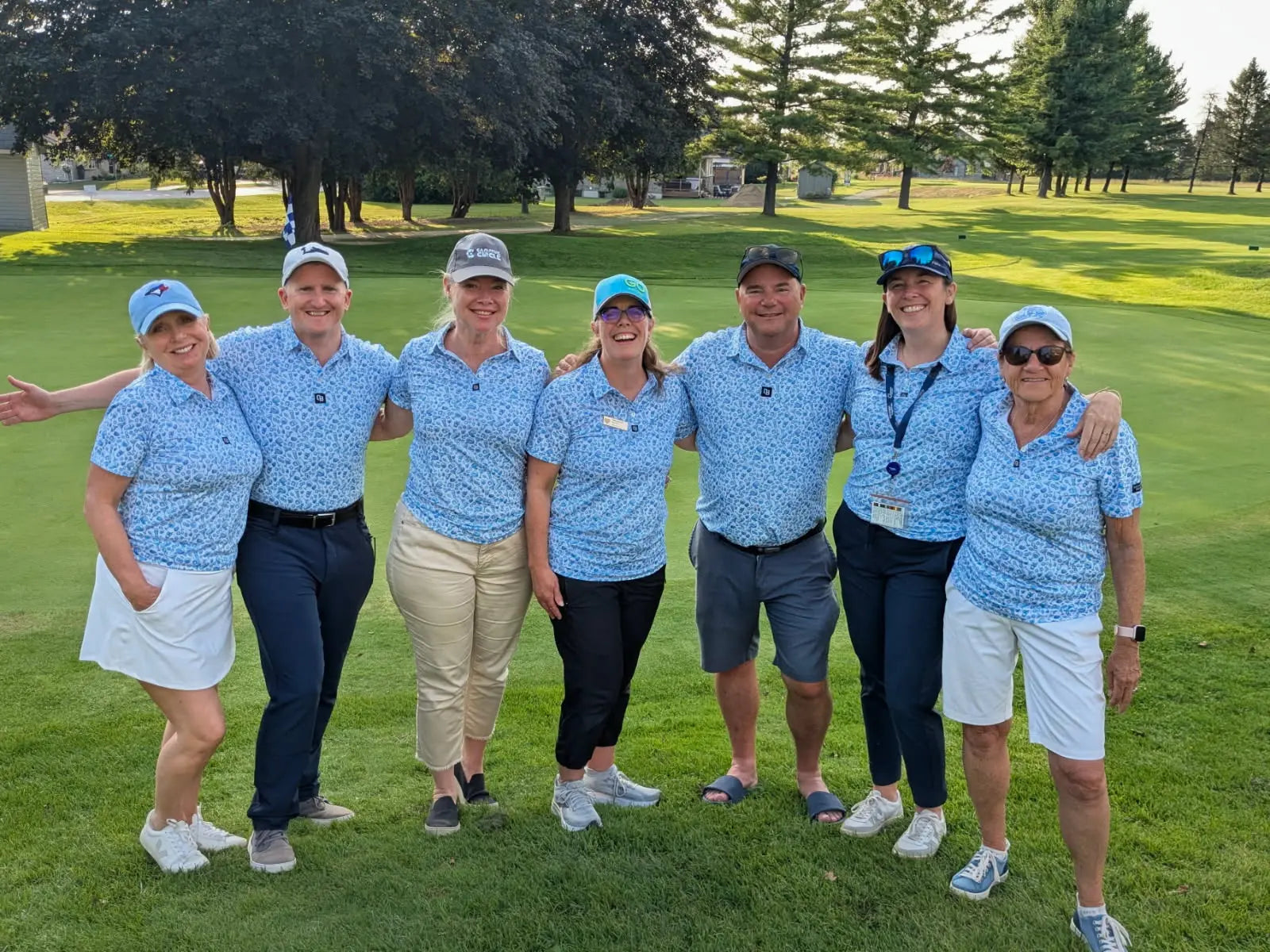 Women golfers wearing coordinating blue Shop Out of Bounds polos on the course